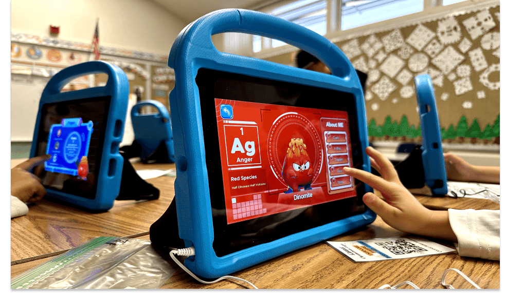 A child touches a tablet showing the Dinomite Anger emotion buddy, a red half-dinosaur half-volcano, in the MEandMine app.