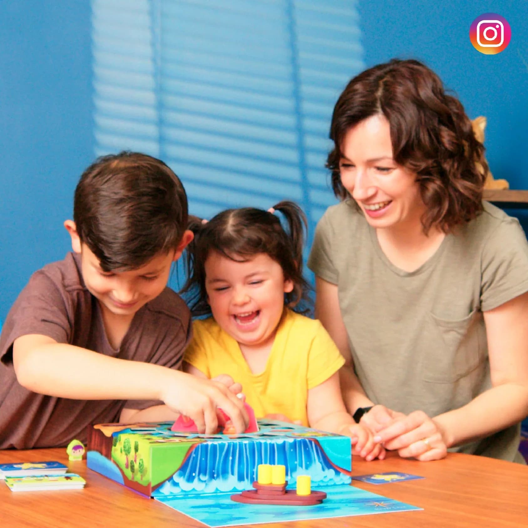 A mother and two children playing a MEandMine board game
