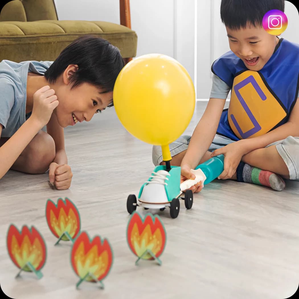 Two boys racing a balloon car