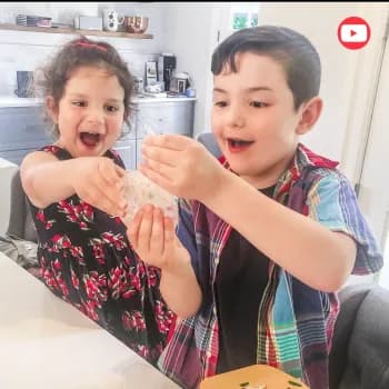 A girl and a boy laughing over a craft