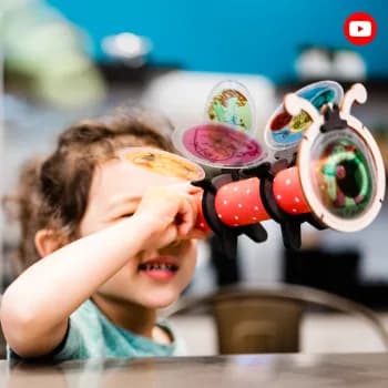 A child looking through a toy telescope