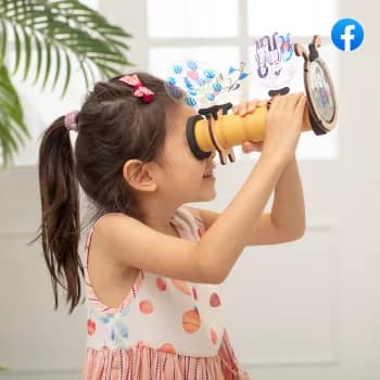 A girl looking through a toy kaleidoscope