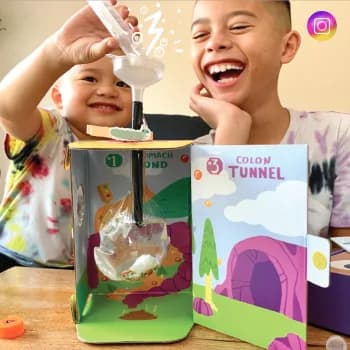 Two boys laughing at a Colon Tunnel kit