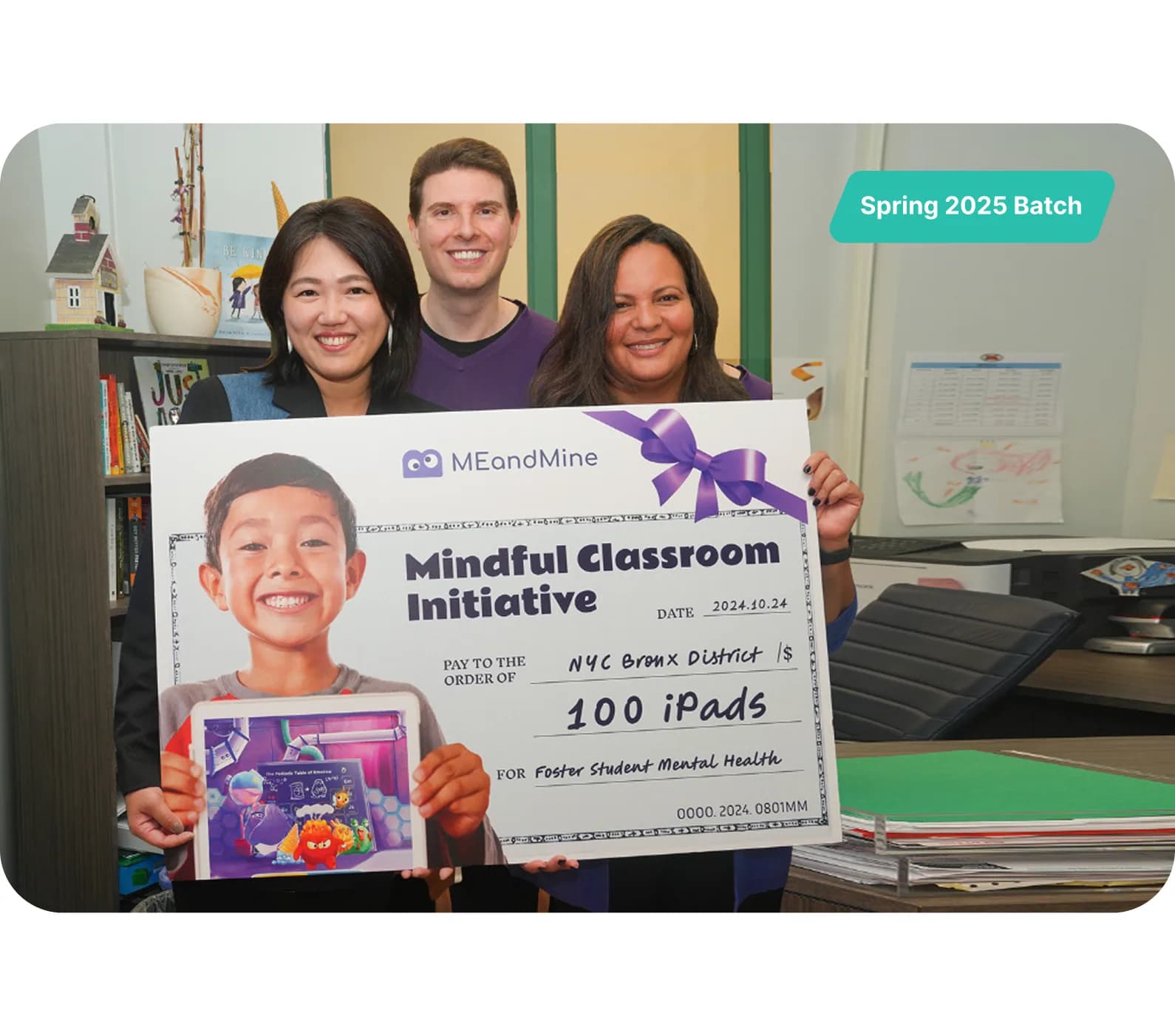 PS 360 staff holding a Mindful Classroom Initiative check for 100 iPads