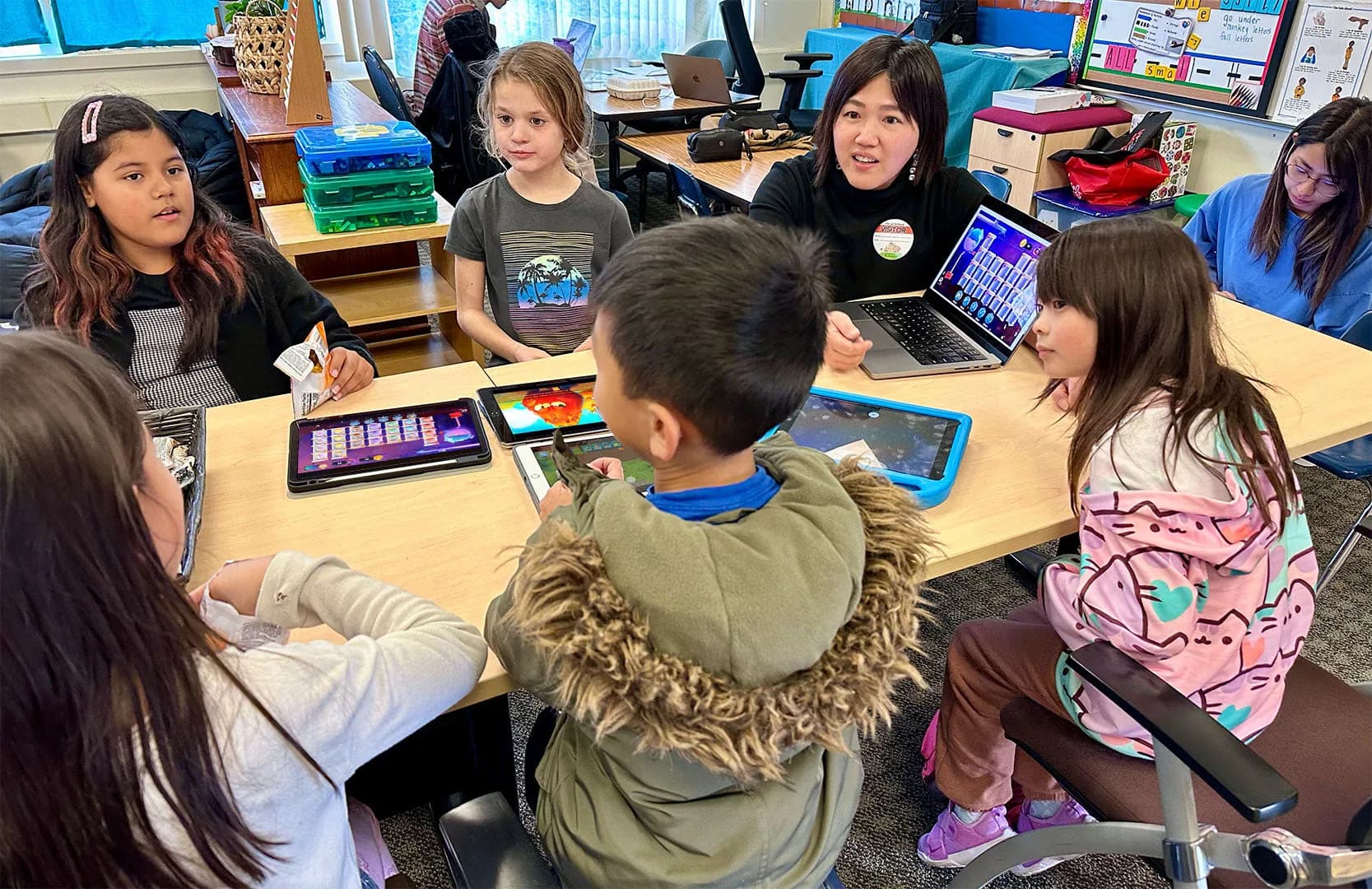 Children playing MEandMine on tablets around a classroom table