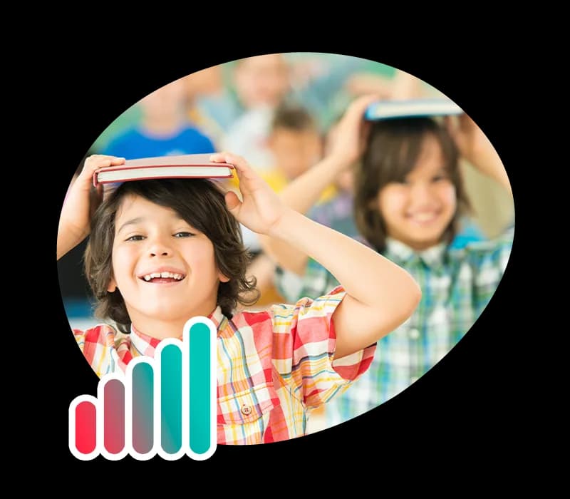 Smiling children balancing books on their heads