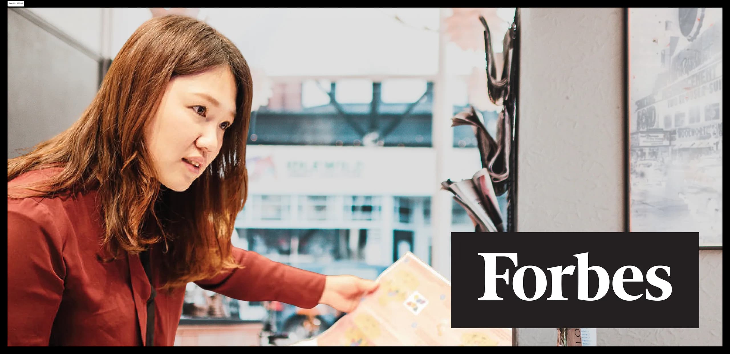 A founder working at a table, with the Forbes logo