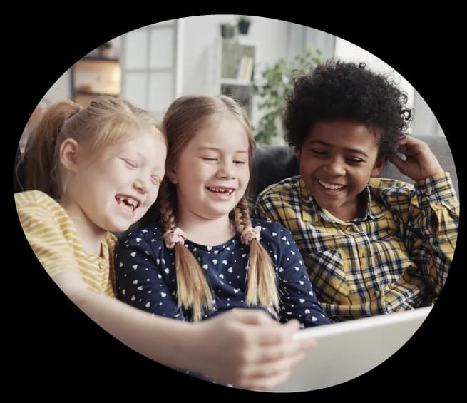 Three children laughing over a tablet
