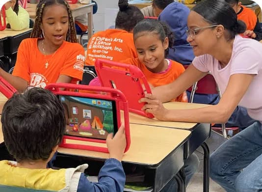 A teacher helping students play MEandMine on tablets in class