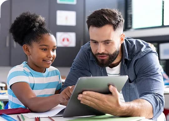 A teacher and a student looking at a tablet together