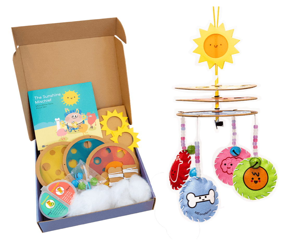 MEandMine Sunshine Mischief kit: an open box with storybook and sun parts beside a finished sun mobile with felt charms.