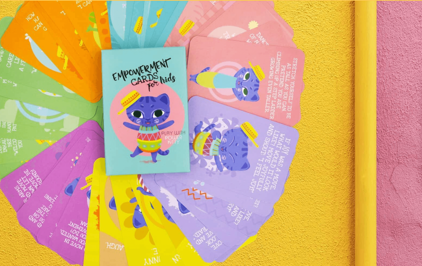 Fan of colorful Empowerment Cards for Kids around a box featuring Power Kitty, each card showing a move to try